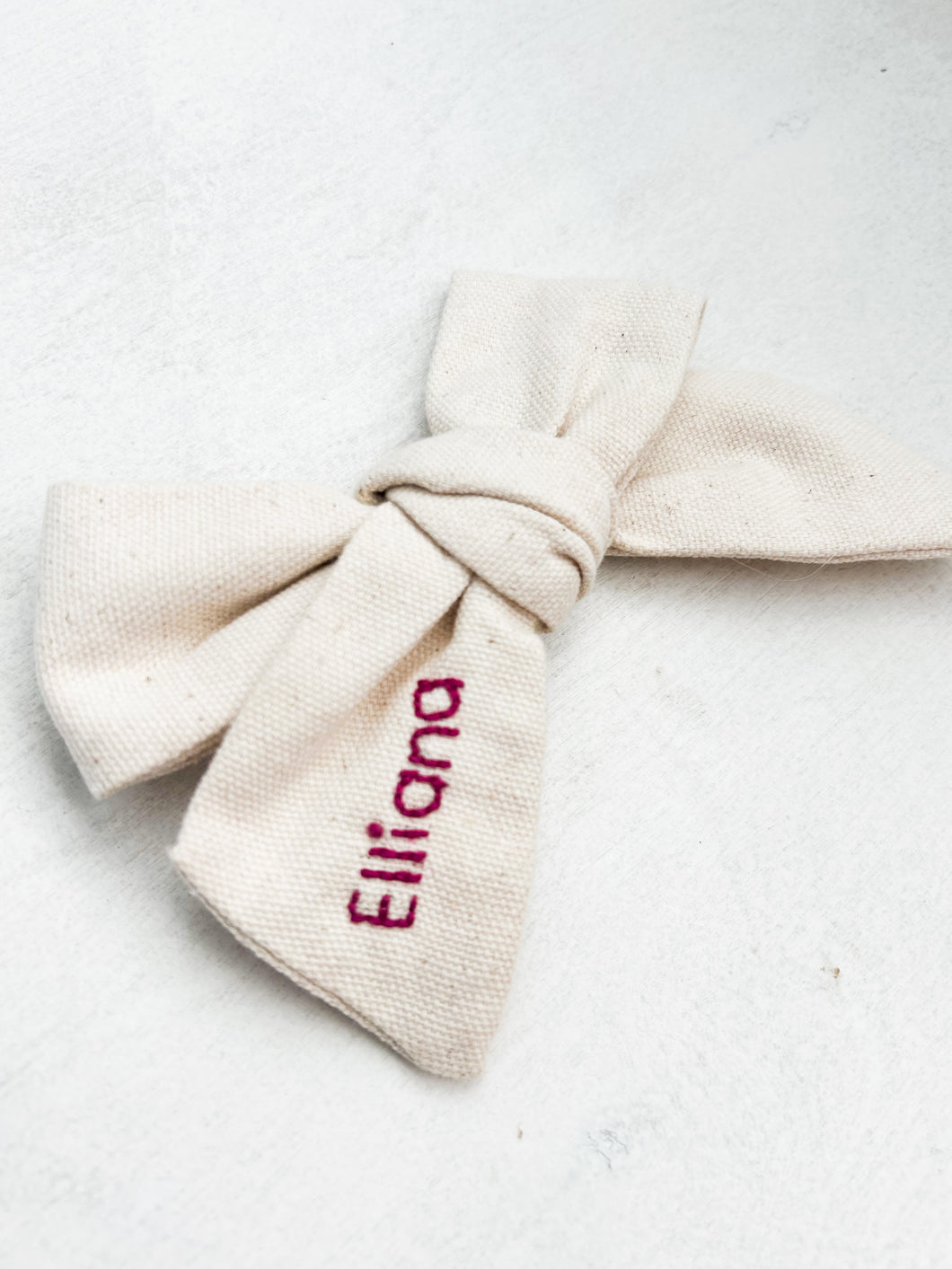 Hand embroidered cream bow